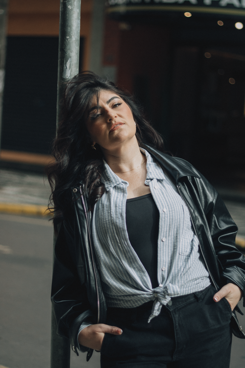 Free Portrait of a woman in urban attire posing confidently on a city street. Stock Photo