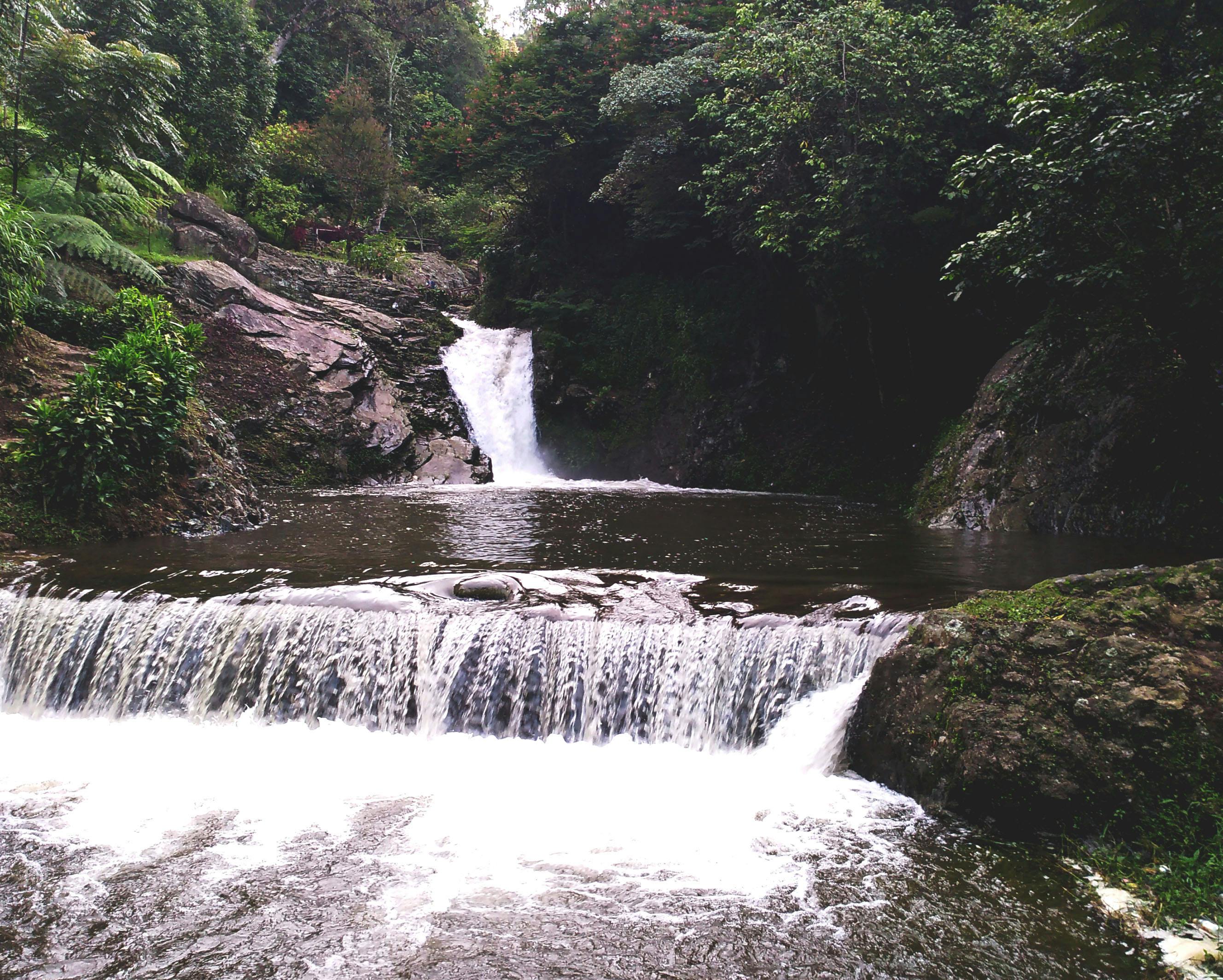Woman sitting peacefully by a lake with mountains in the background