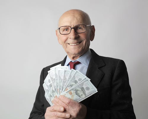 Free Man In Black Suit Holding Dollar Bills Stock Photo