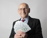 Man In Black Suit Holding Dollar Bills