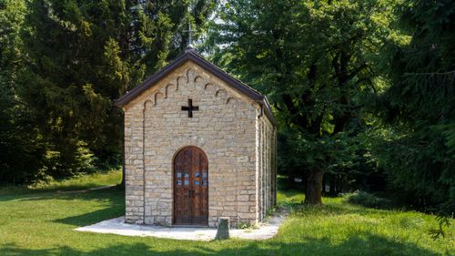 Free Charming stone chapel nestled amidst greenery in Ortanella, Italy, under a clear summer sky. Stock Photo