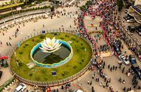 Aerial shot capturing a vibrant parade around a city lotus fountain.