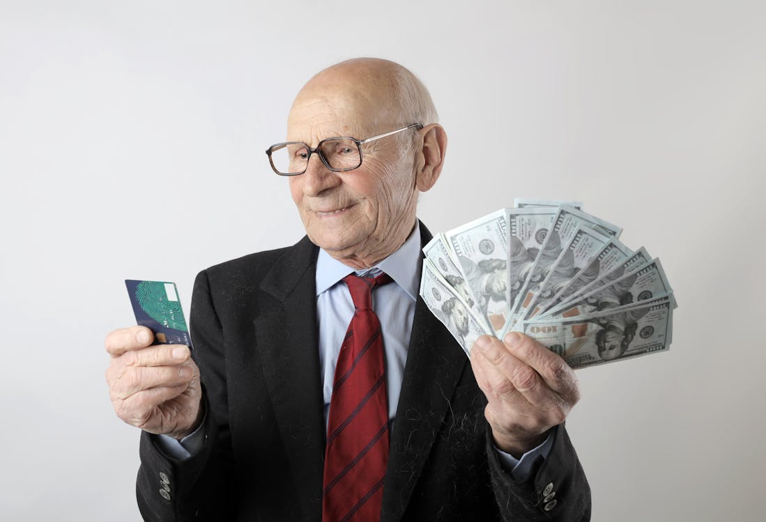 Free Man In Black Suit Holding Banknotes And Credit Card Stock Photo