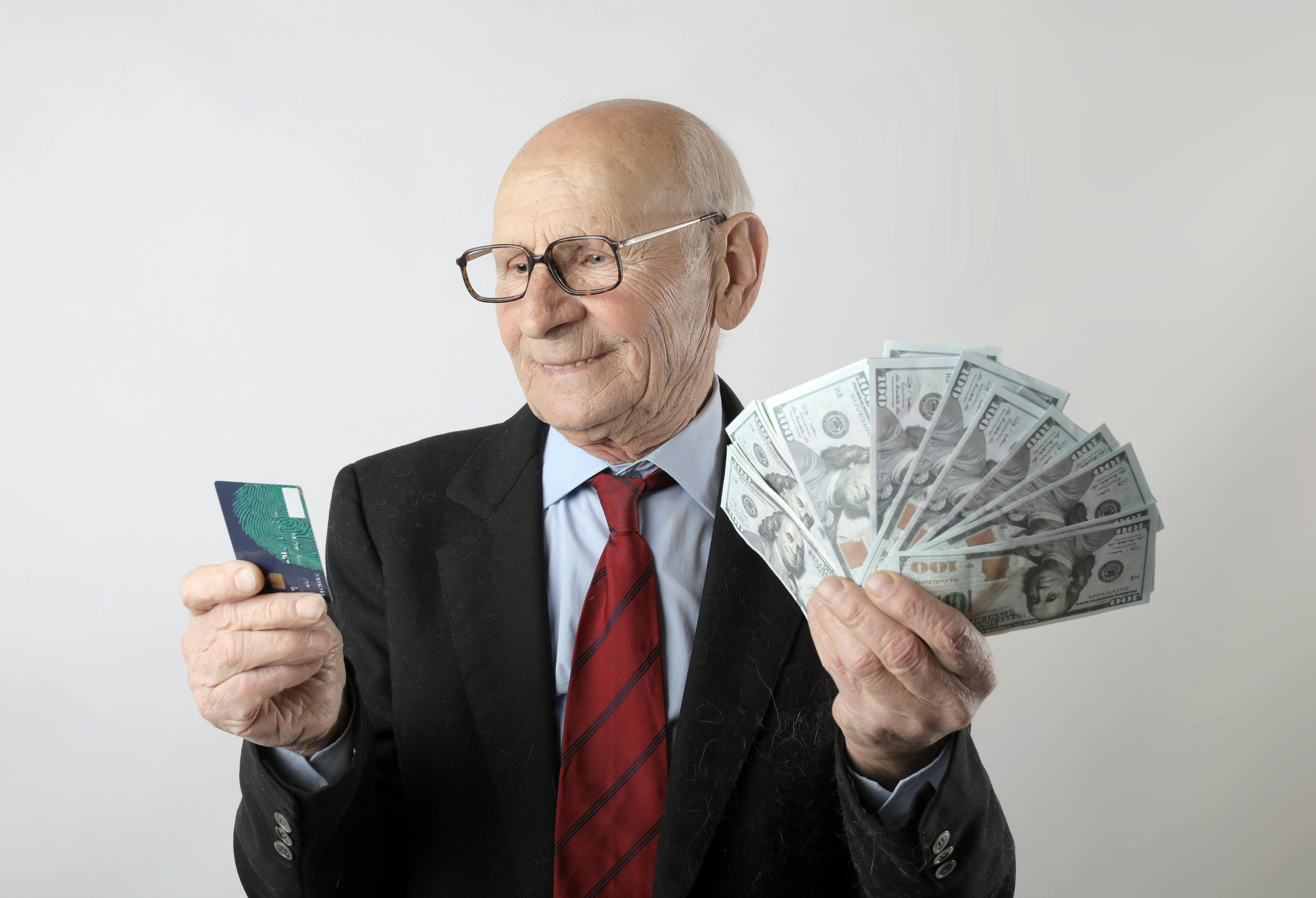 Man Holding U.s Dollar Banknotes and Black Leather Bi-fold ...