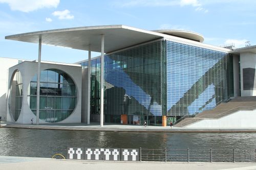 Free The Paul-Löbe-Haus in Berlin showcases modern architecture along the river under a clear sky. Stock Photo