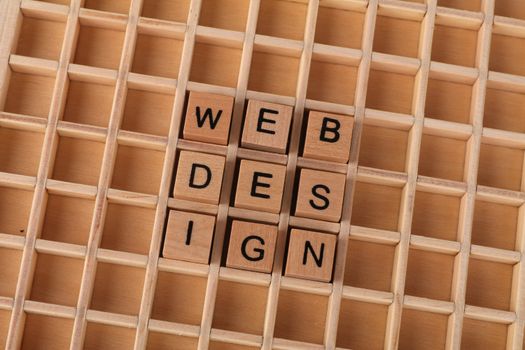 Wooden blocks spelling web design on a grid background symbolizing creative digital design concepts.