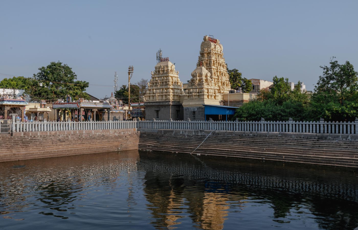 Temple tank and gopurams in the morning sun — representative image