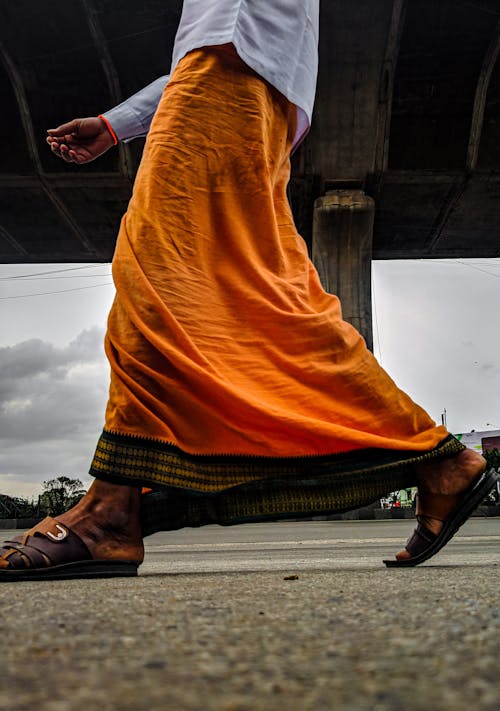 Man in Orange Skirt Walking