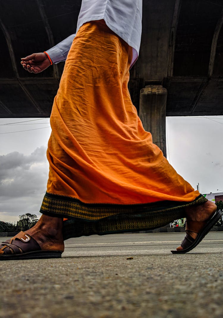 Man In Orange Skirt Walking