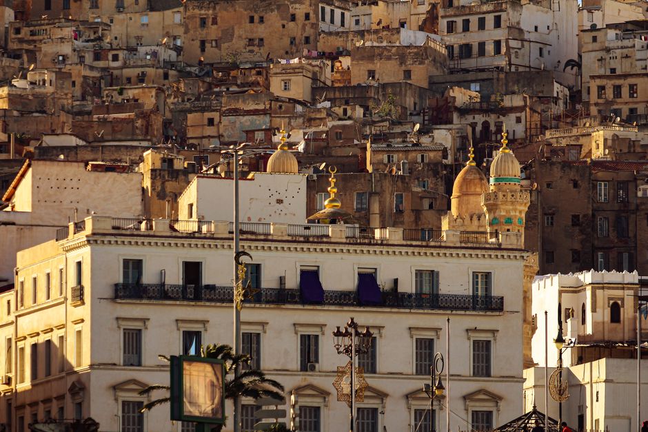 Distant view of historic buildings in Algiers, highlighting diverse architecture at dusk.