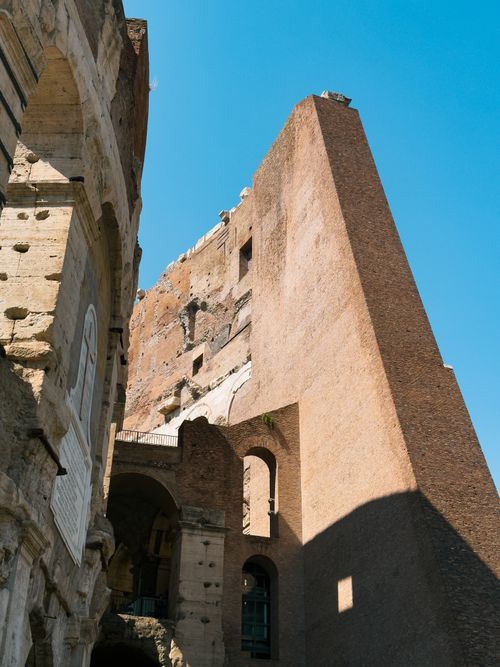 Free Stunning view of the ancient Colosseum's exterior walls in Rome, Italy under a clear blue sky. Stock Photo