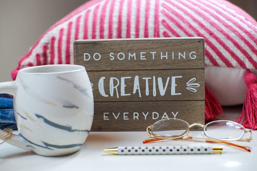 Stylish desk setup with a coffee mug, eyeglasses, and motivating sign.