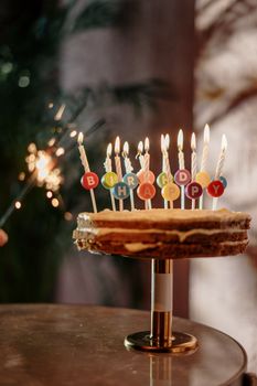 A delicious cake with lit candles spelling 'Happy Birthday' on a table, creating a festive atmosphere.