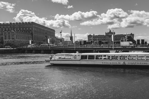 Free Monochrome view of Stockholm cityscape with a sightseeing boat, Royal Palace, and beautiful clouds. Stock Photo