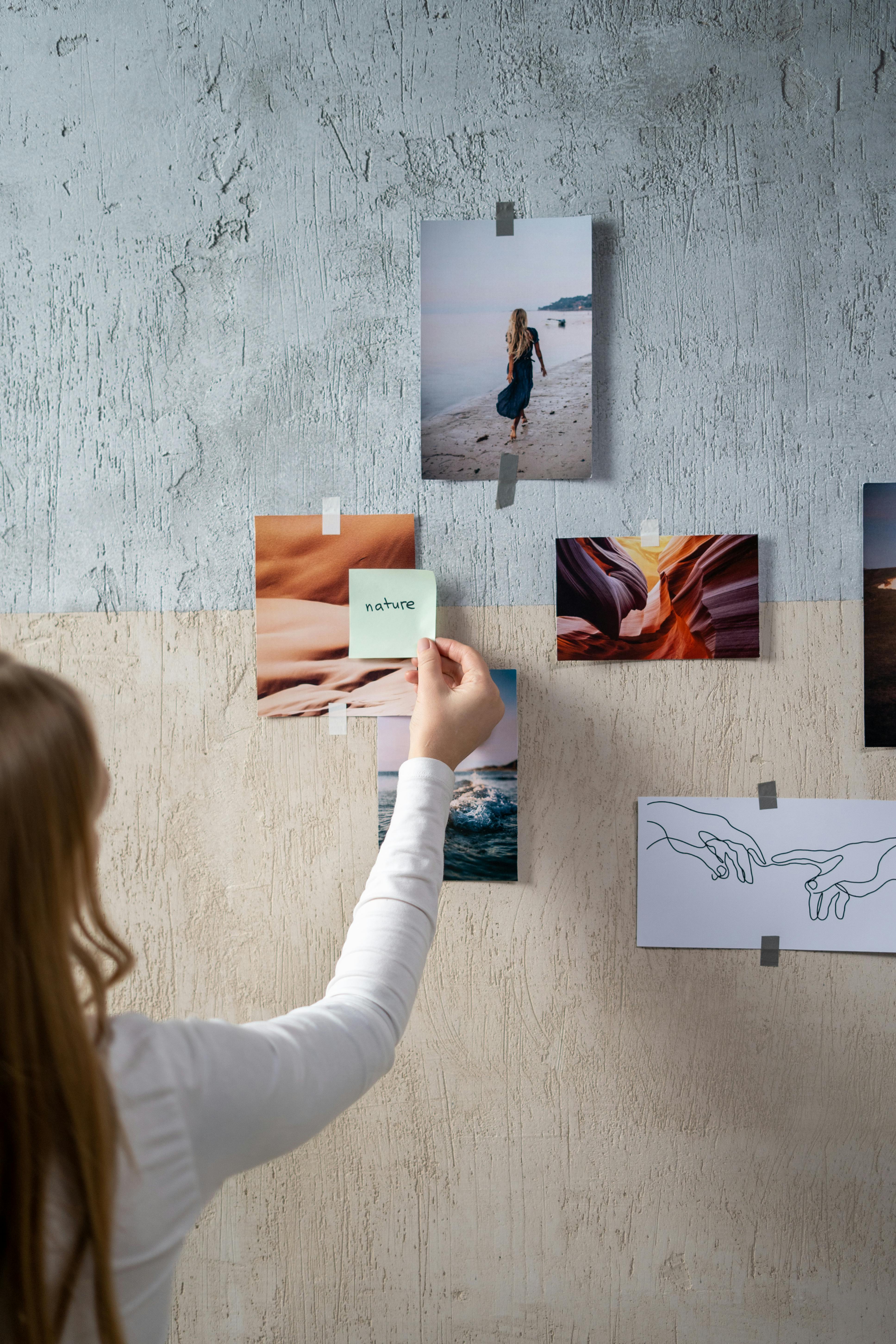 back view of a woman putting a sticky note on a moodboard