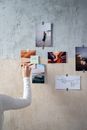 A Person Sticking Photos on a Wall