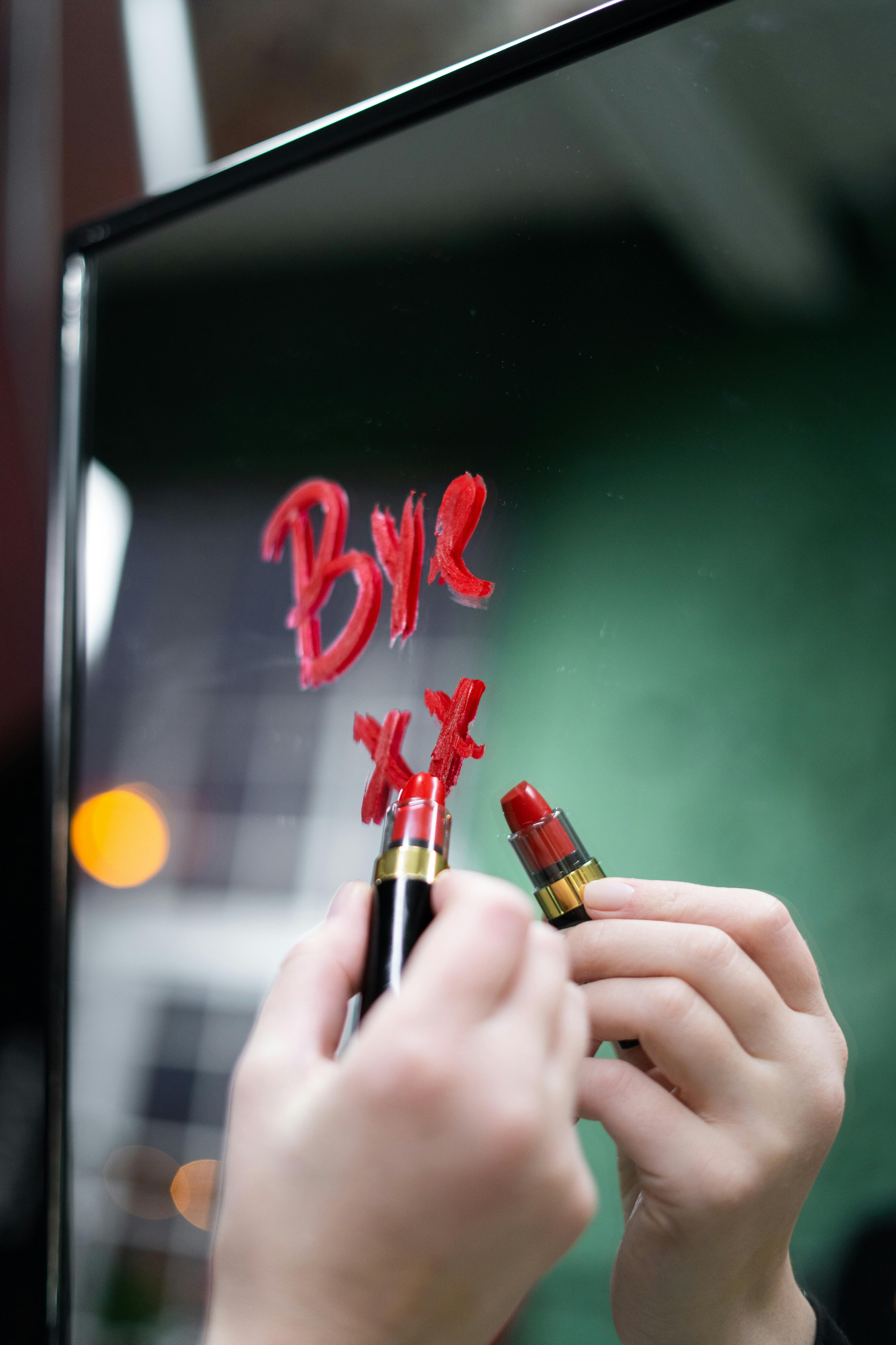 person holding red lipstick