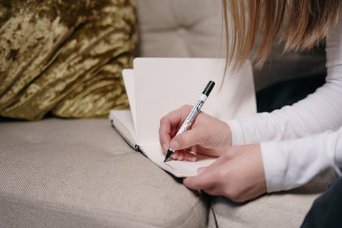 Persoon In Wit Shirt Met Lange Mouwen Met Een Pen Schrijven Op Wit Papier