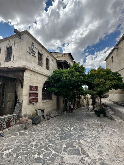 Free Picturesque street in Cappadocia, Türkiye, showcasing historic architecture under a dramatic sky. Stock Photo