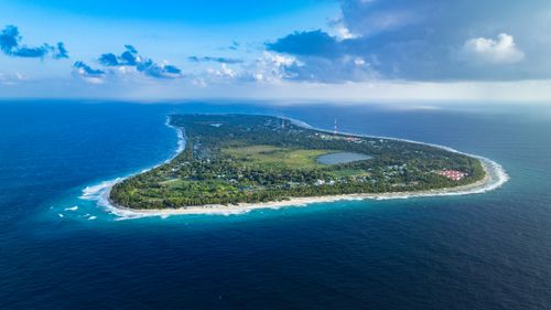 Free Discover the natural beauty of Fuvahmulah Island in the Maldives, captured from above with lush greenery and azure waters. Stock Photo