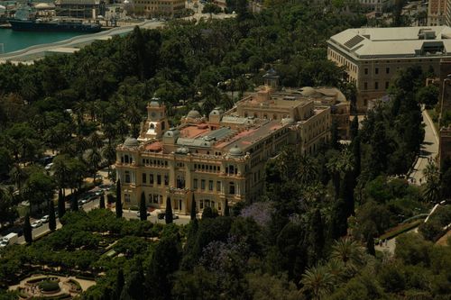 Free A stunning aerial view of a historic building surrounded by lush greenery and gardens, captured on a sunny day. Stock Photo
