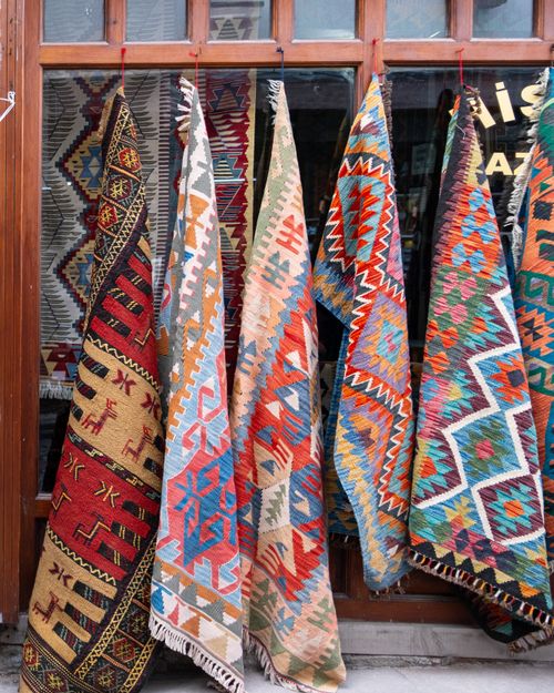 Free Vibrant traditional Turkish kilims on display in an Ankara bazaar, showcasing rich patterns and colors. Stock Photo