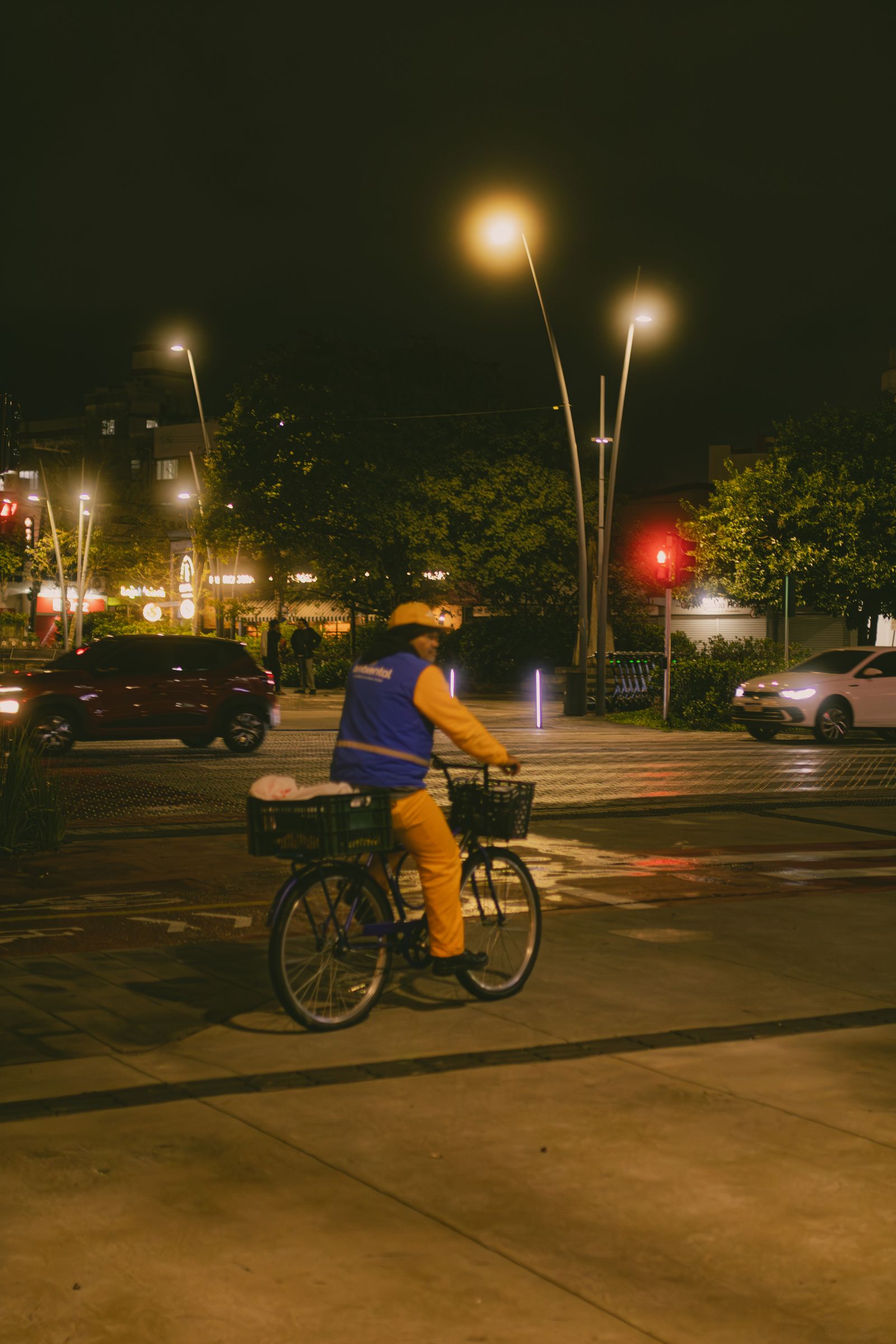 Urban cyclist riding through a city street at night
