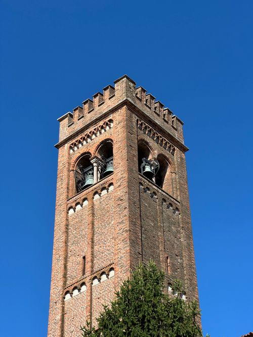 Free A picturesque view of a historic brick bell tower with blue sky in Mantova, Italy. Stock Photo