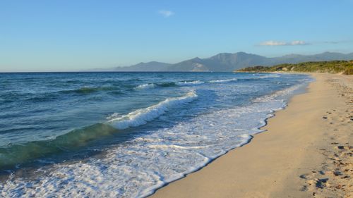 Free Discover the untouched beauty of a wild beach in Corse, France, with clear waves and picturesque views. Stock Photo