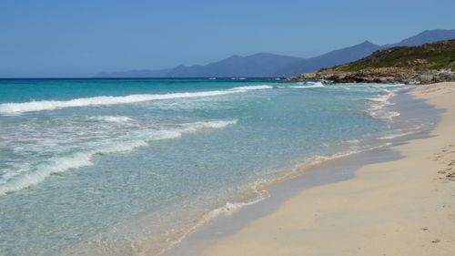 Free Tranquil coastline with clear blue waters and white sand on Corse, France. Stock Photo