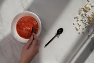 在大理石表面，扁平的素食番茄汤与字母意大利面拼出“素食”字样