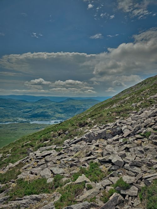 Free Stunning landscape of the Irish countryside with rocky slopes and rolling hills under a blue sky. Stock Photo