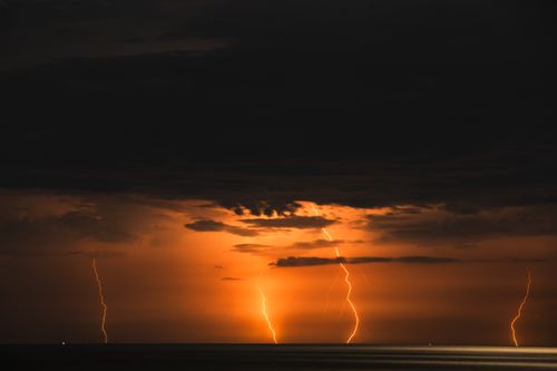 Free Vivid lightning strikes illuminate the night sky over the ocean in Cửa Tùng, Vietnam. Stock Photo