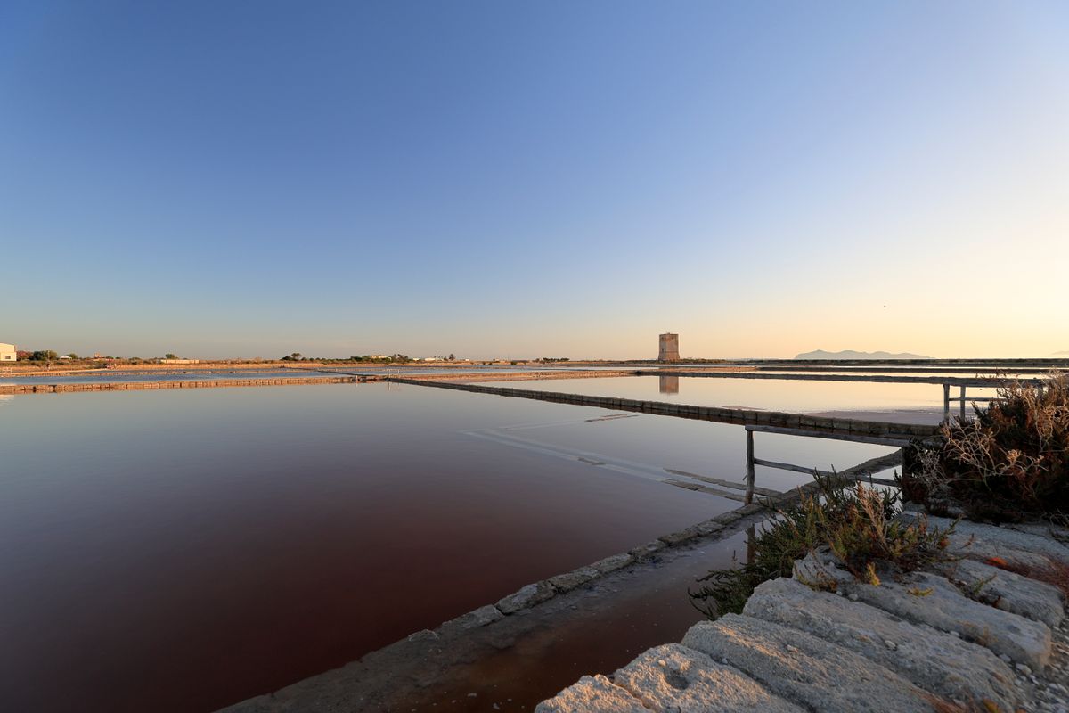 The Saline di Trapani at sunset — pink evaporation pans and centuries-old windmills.