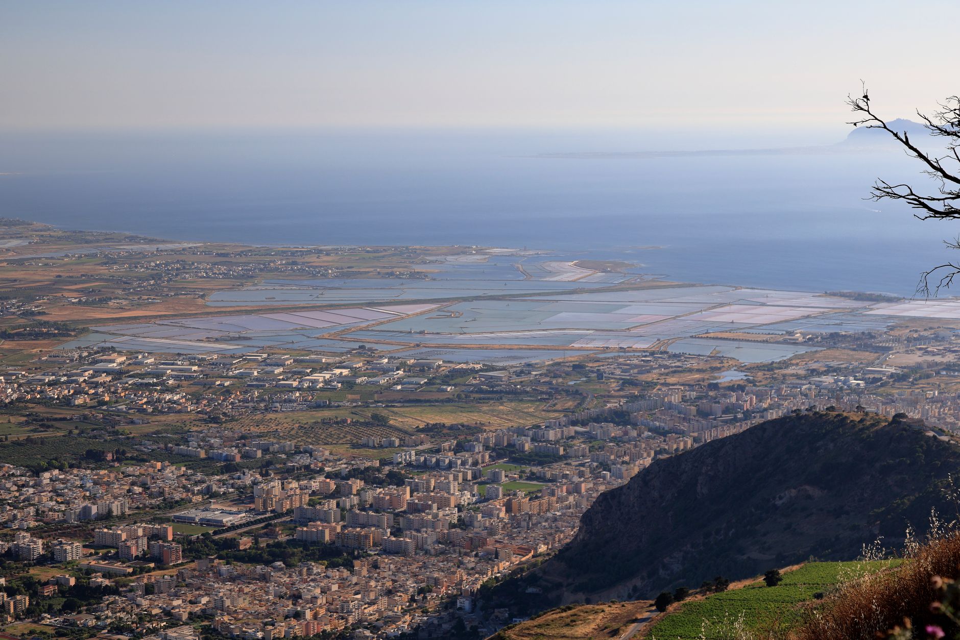Stunning aerial view of Trapani coastline, showcasing salt pans and lush landscape against the blue sea.