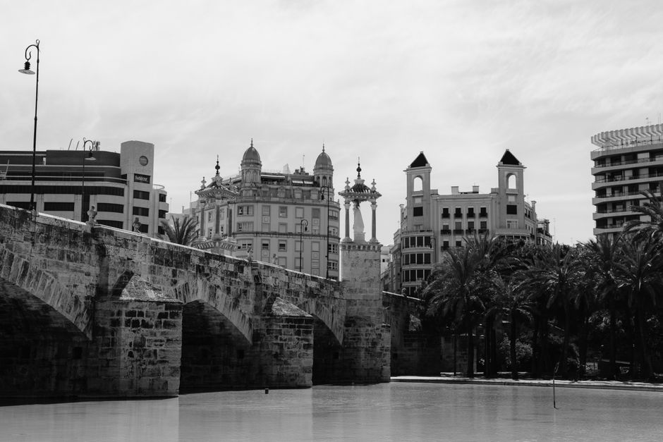 Fotografía en blanco y negro de la arquitectura de Valencia y su histórico puente sobre el río Turia.