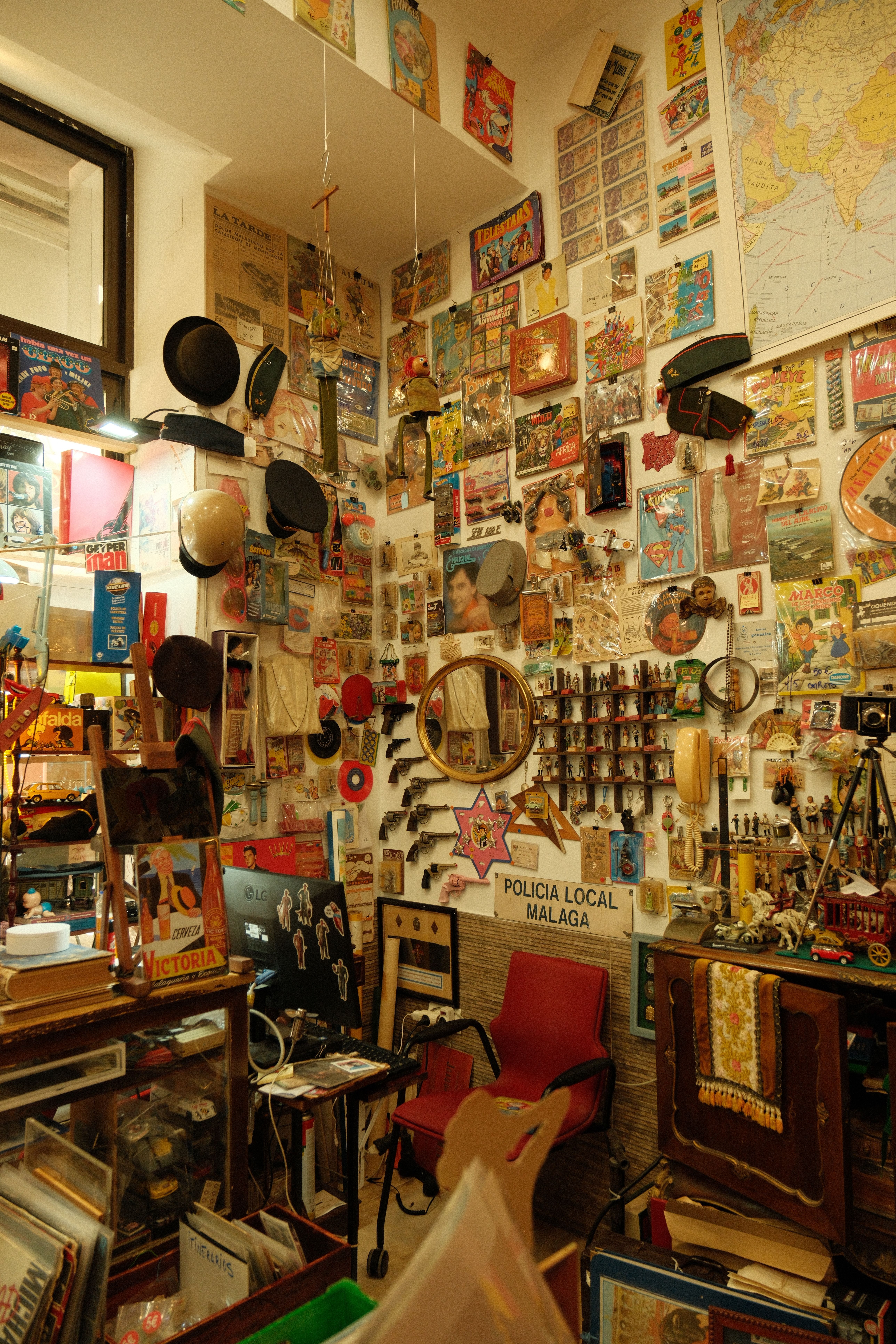Explore a vintage shop in Málaga, Spain filled with eclectic antiques and colorful memorabilia.