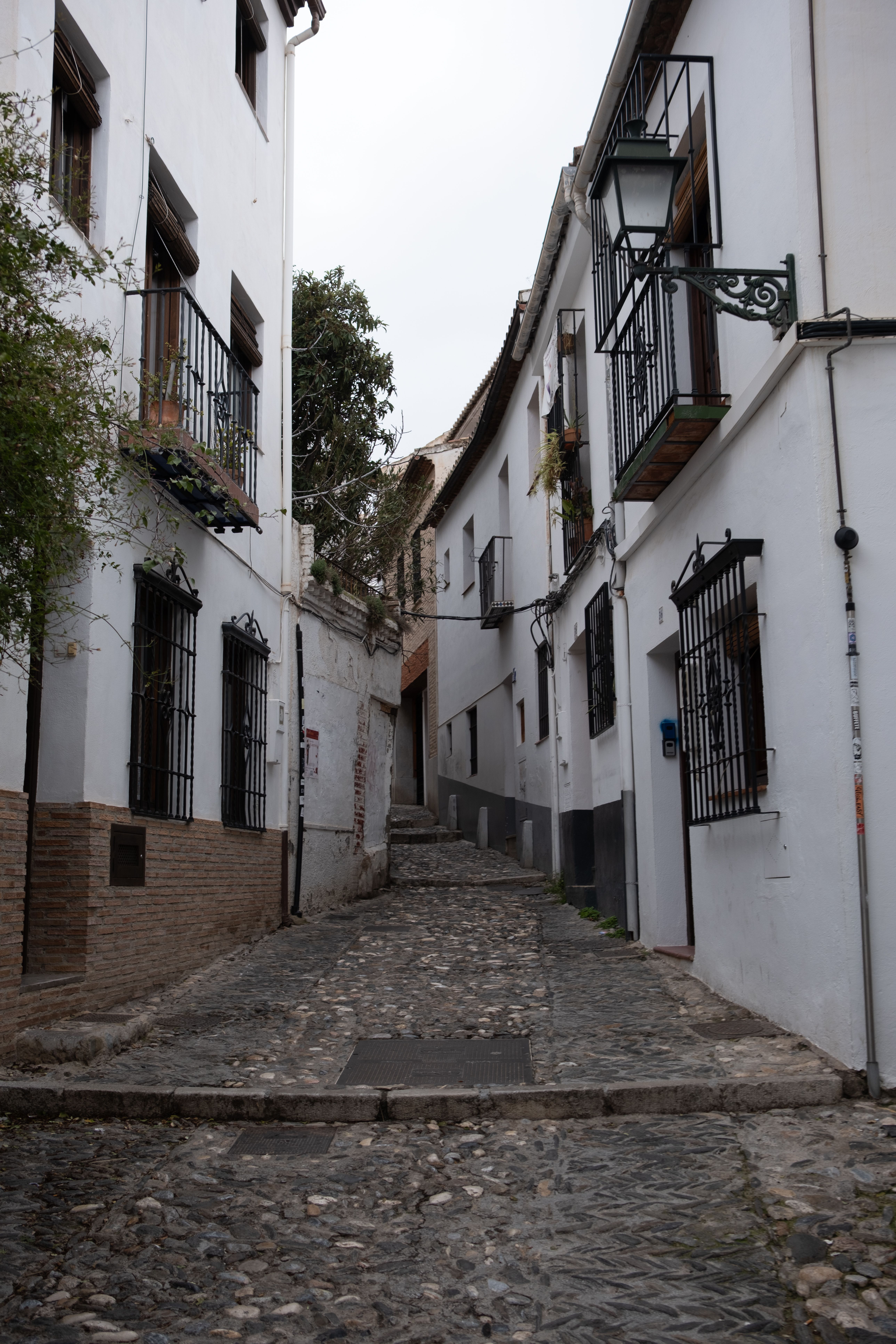 Discover a picturesque cobblestone street with traditional white buildings in Spain's charming villages.