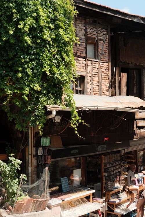 Free A cozy, rustic shop facade adorned with greenery in a historic market district, capturing a nostalgic charm. Stock Photo