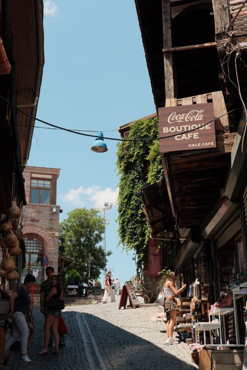 Free Cobblestone street with vibrant shops and cafes, capturing lively European atmosphere. Stock Photo
