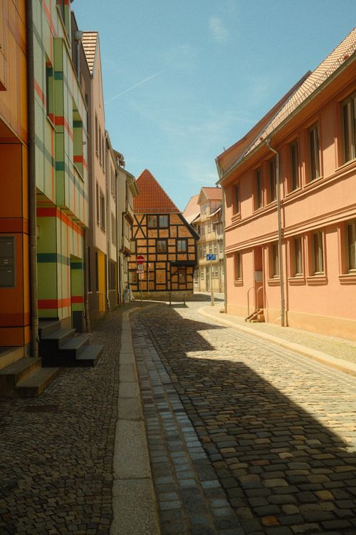 Free Quaint street scene in Quedlinburg, Germany, featuring half-timbered houses and cobblestone paths. Stock Photo