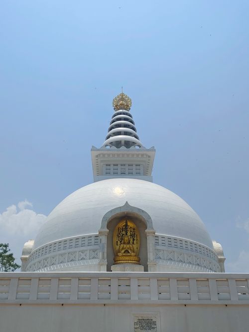Free Serene view of a white stupa with golden accents under a clear blue sky. Stock Photo