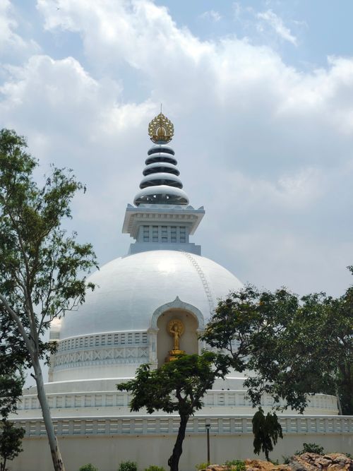 Free A stunning Peace Pagoda against a bright blue sky surrounded by greenery. Stock Photo