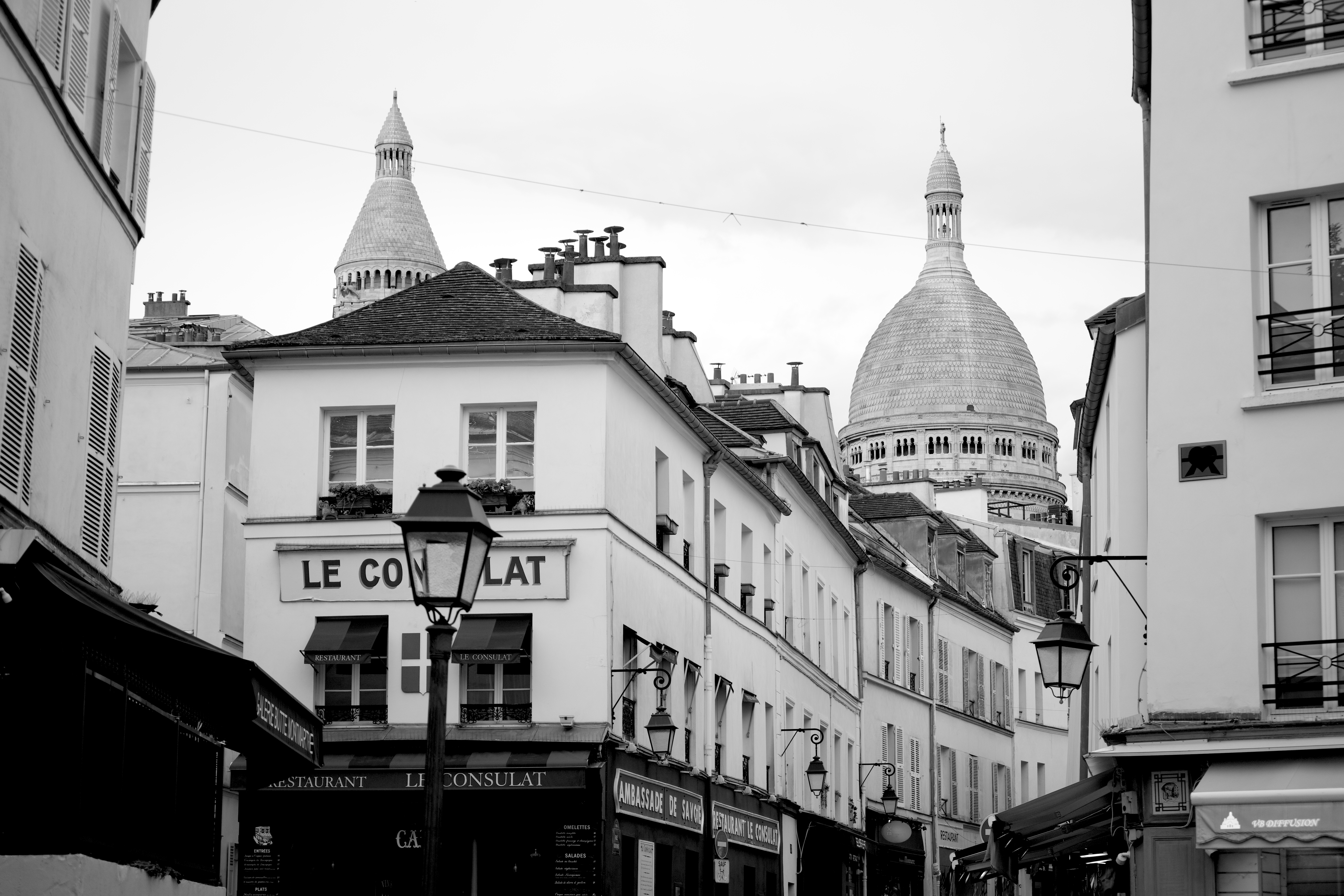 Charming black and white street view in Montmartre, featuring Sacré-Cœur Basilica. — quartier emblématique du 18e, zone d'intervention Mister Concierge