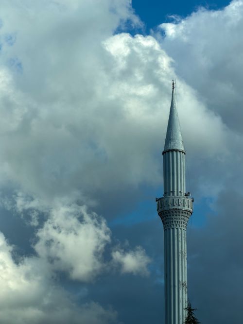 Free A striking minaret under a dramatic sky with fluffy clouds, capturing the architectural beauty. Stock Photo