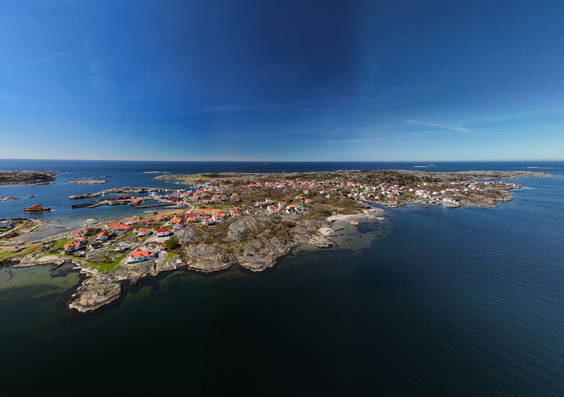 Aerial view of a picturesque Swedish coastal village with vibrant rooftops and tranquil waters. — photo by Zsolt B / Pexels