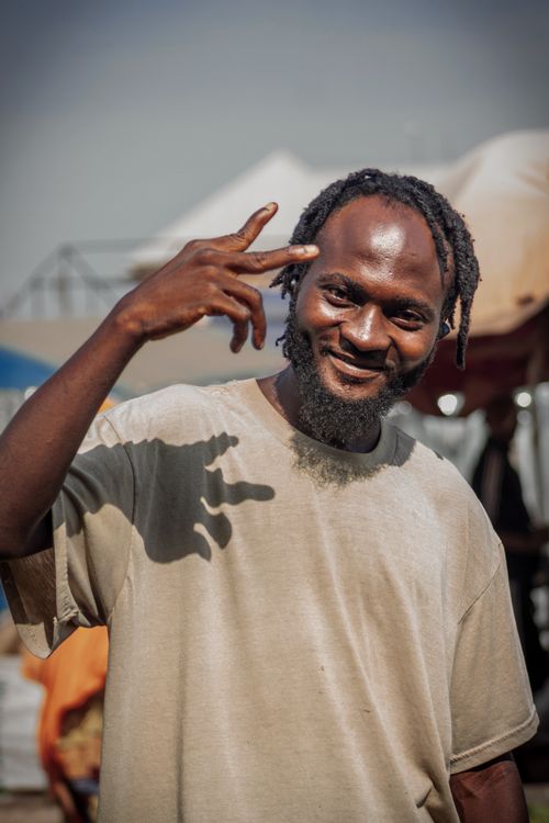 Free Casual outdoor portrait of a smiling man in Kaduna, Nigeria, showcasing vibrant street life. Stock Photo