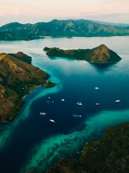 Stunning aerial capture of Bali islands with boats on turquoise waters.