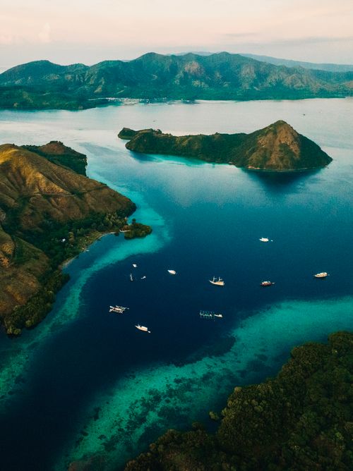 Free Stunning aerial capture of Bali islands with boats on turquoise waters. Stock Photo