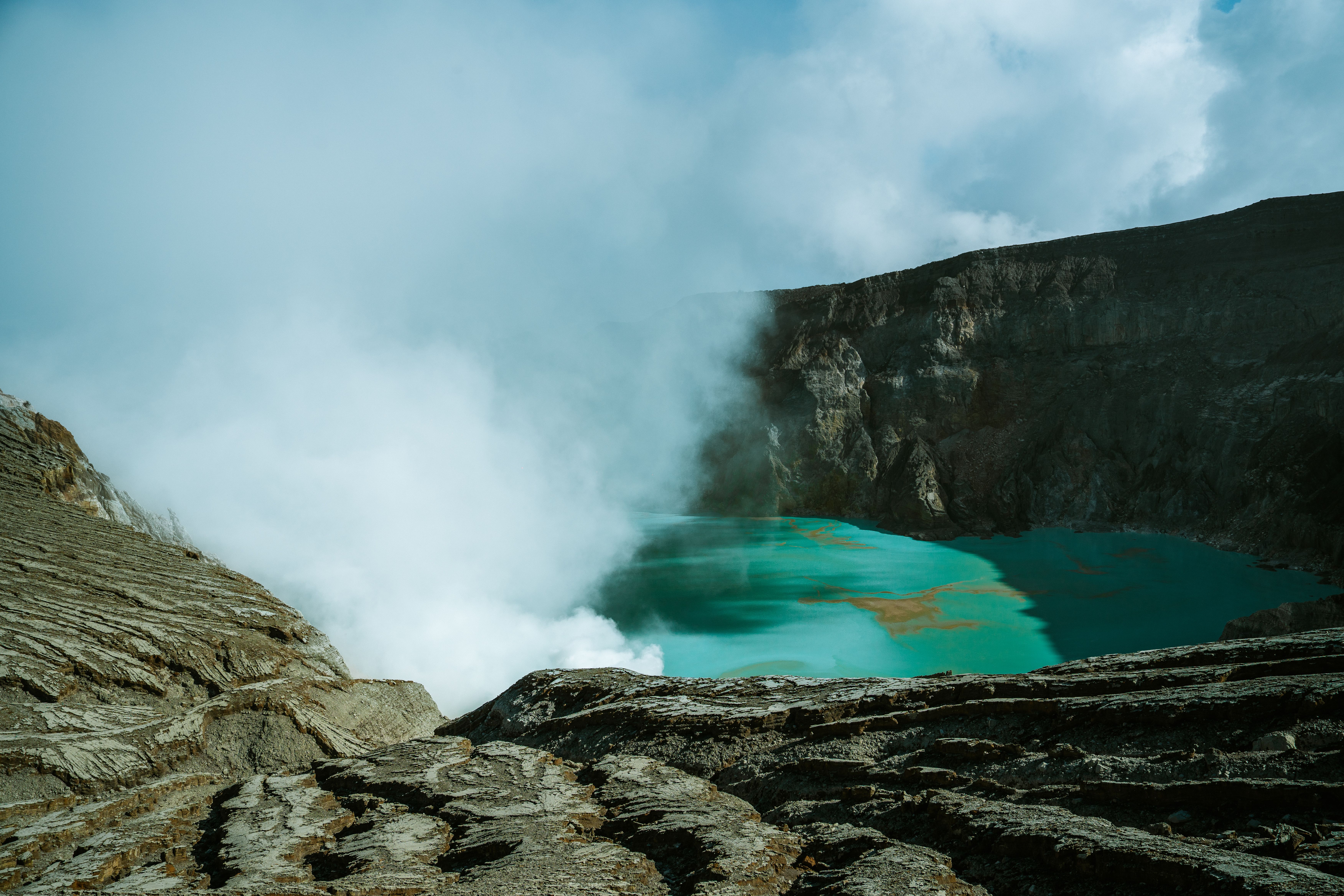 Stunning view of Ijen Crater’s turquoise lake with steaming sulfur gases in East Java, Indonesia.